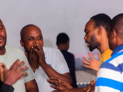 Un groupe de membres prie ensemble, les mains tendues