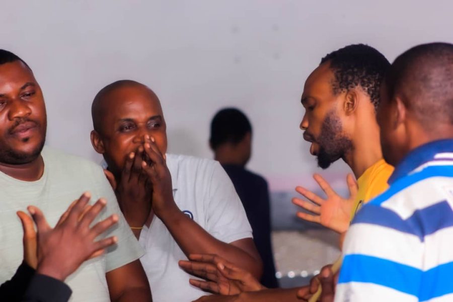Un groupe de membres prie ensemble, les mains tendues